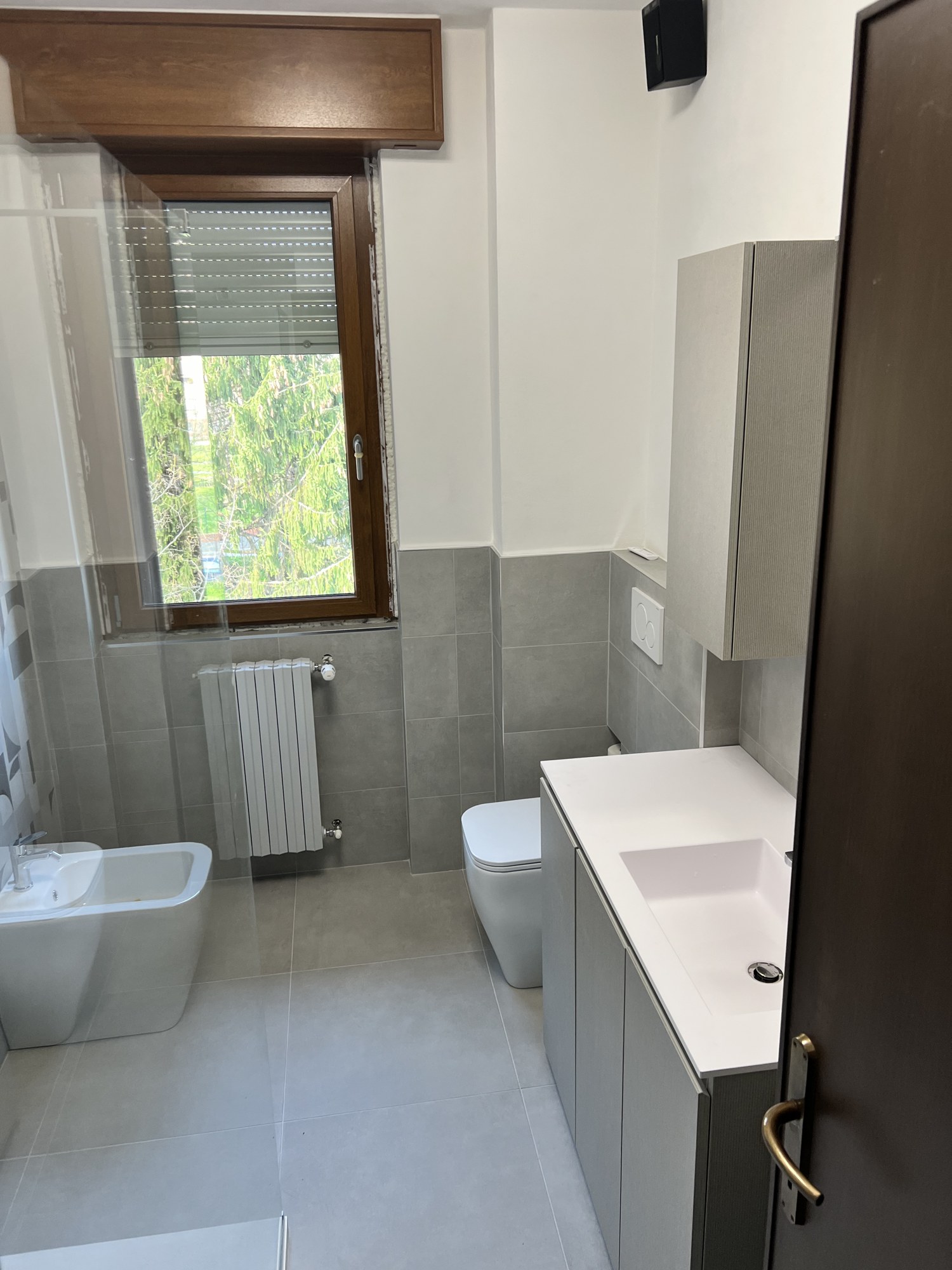 Bagno grigio con doccia walk-in e piastrelle geometriche